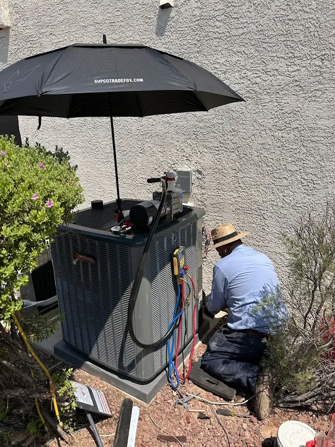 HVAC technician performing outdoor AC maintenance in Florida Gulf Coast University