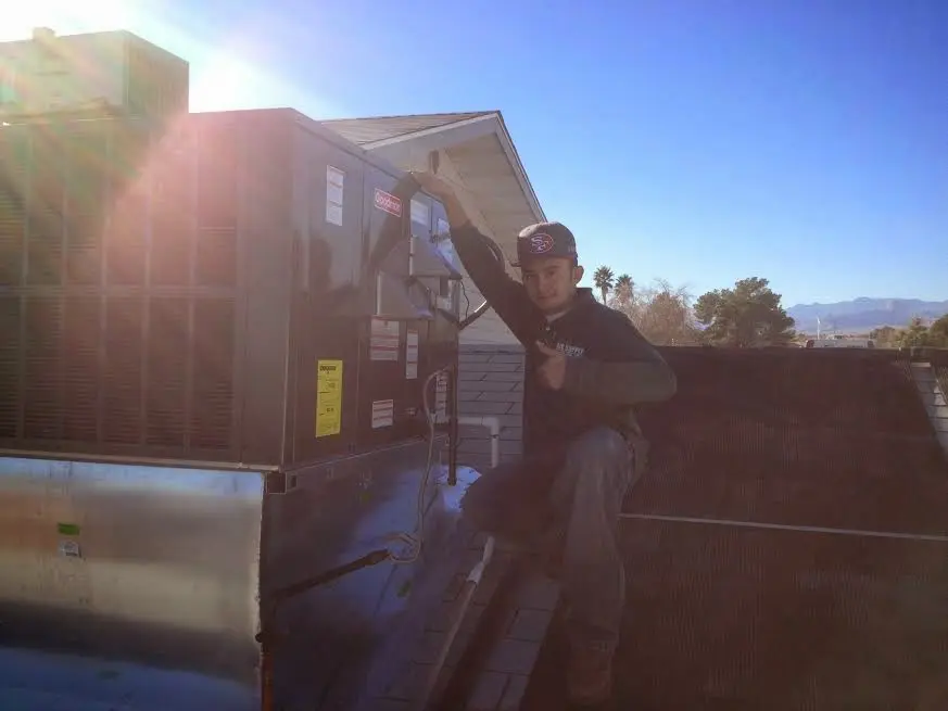 HVAC technician performing Heat Pump Repair on a rooftop unit in Florida Gulf Coast University